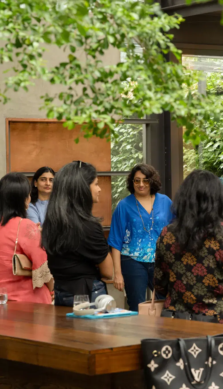 Guests talking around a table on a leafy terrace