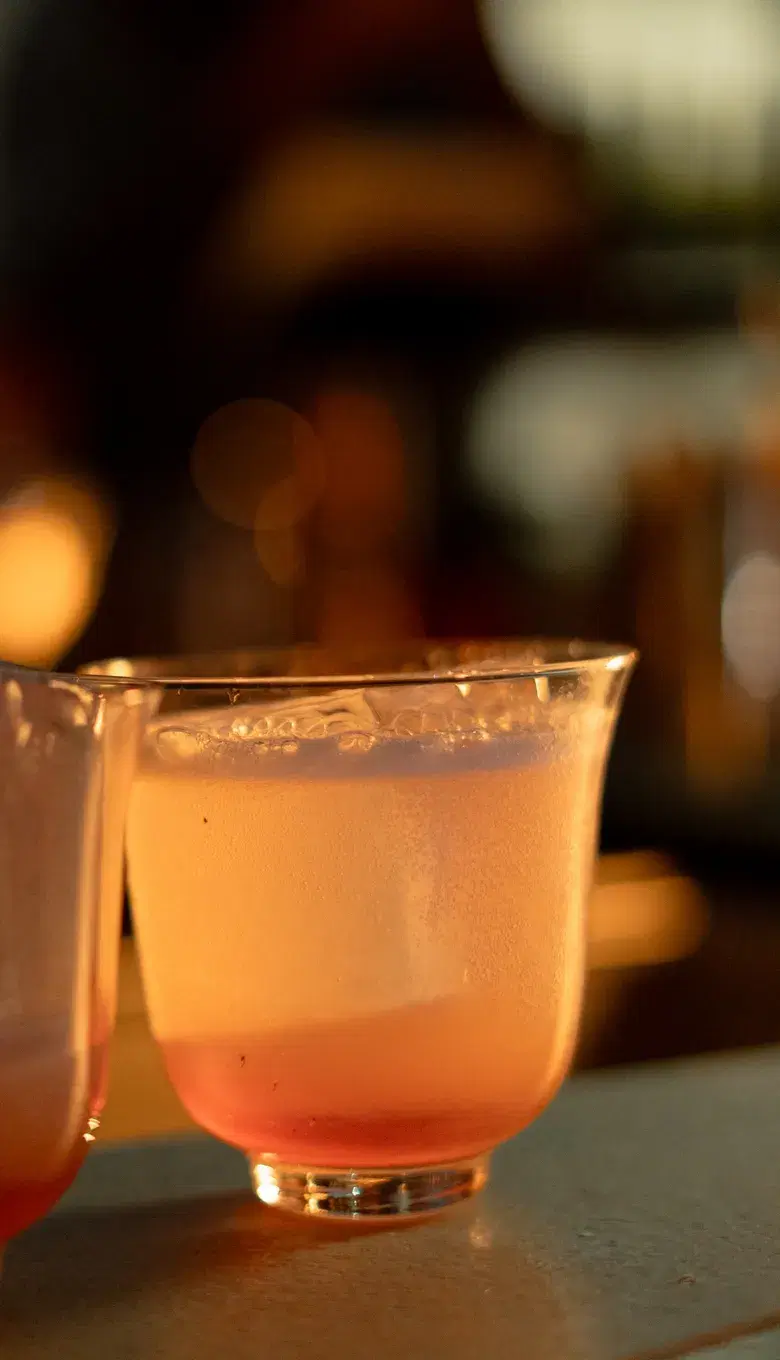 A glowing cocktail glass in close-up by candlelight