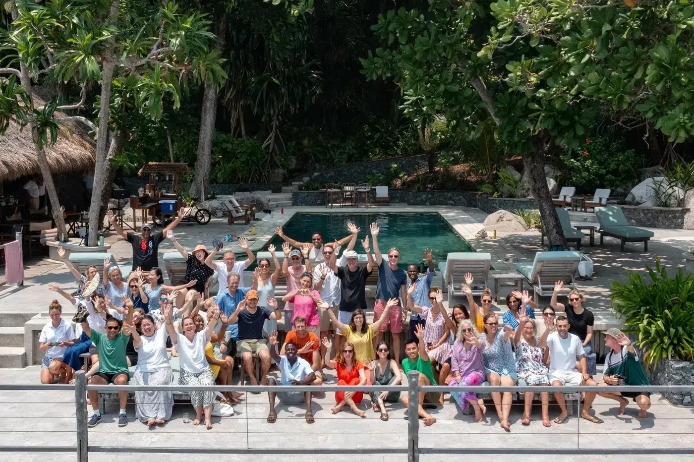 Members of the Postcard community waving together beside a pool