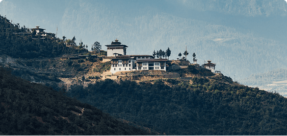 A dzong on a forested ridge in the Bhutanese hills