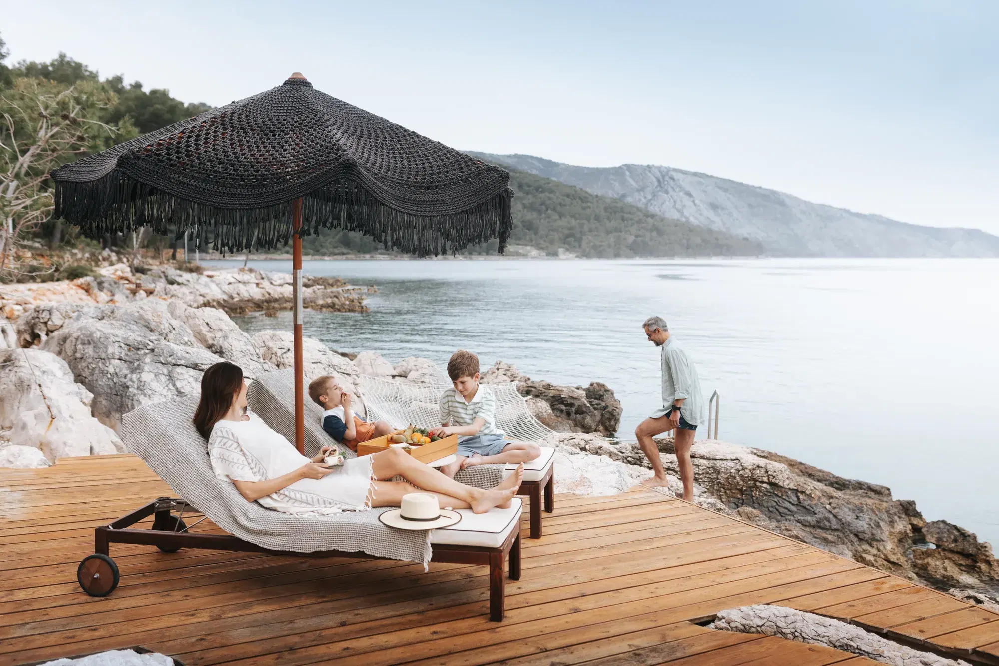 Sun loungers on a timber deck above a calm sea