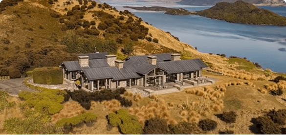 A stone lodge on a hillside above a lake