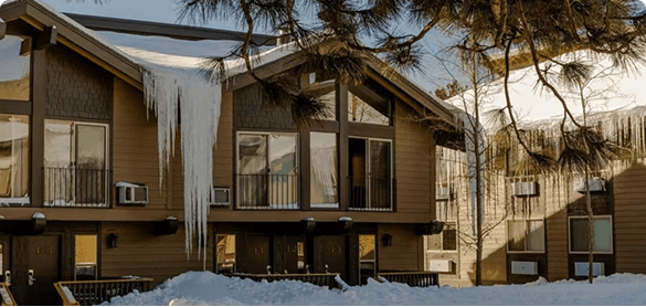A timber lodge hung with icicles after a snowfall
