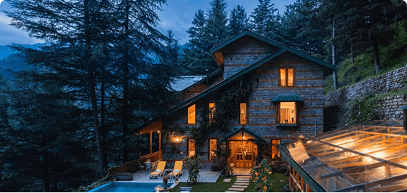 A stone-and-timber mountain house among cedars at twilight